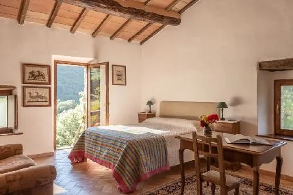 Una camera con letto matrimoniale e vista sul bosco